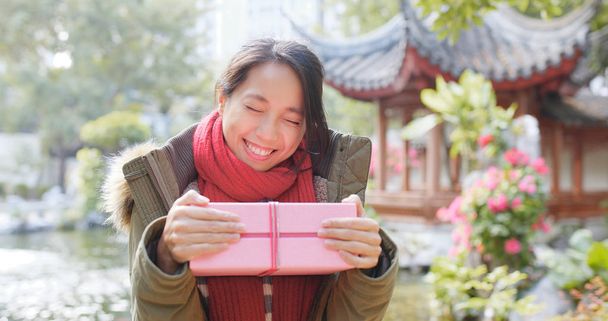 Happy woman receiving a gift box in china  - Photo, Image