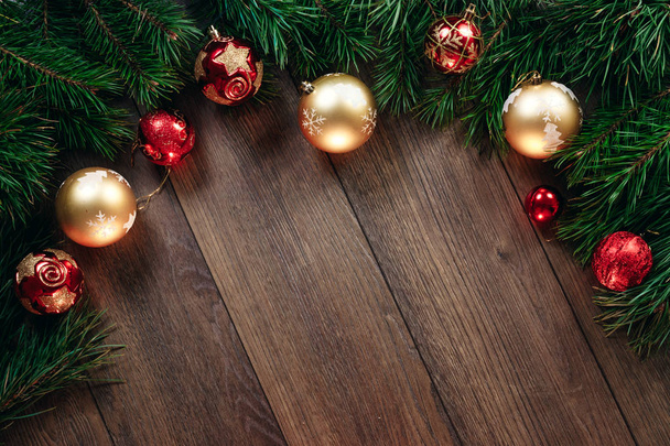Karácsonyi díszek és fenyőágak egy fa asztalon. Ünnepek karácsonyi háttér. Másolja le a helyet a szöveg vagy a design. Kilátás felülről. - Fotó, kép