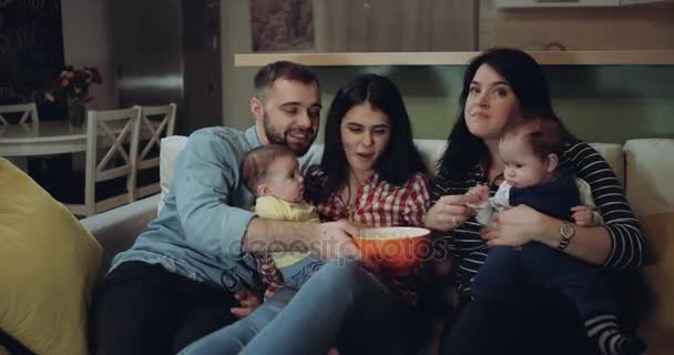 Feliz gran familia viendo la televisión junto con sus bebés y comiendo palomitas de maíz. épica roja
 - Imágenes, Vídeo