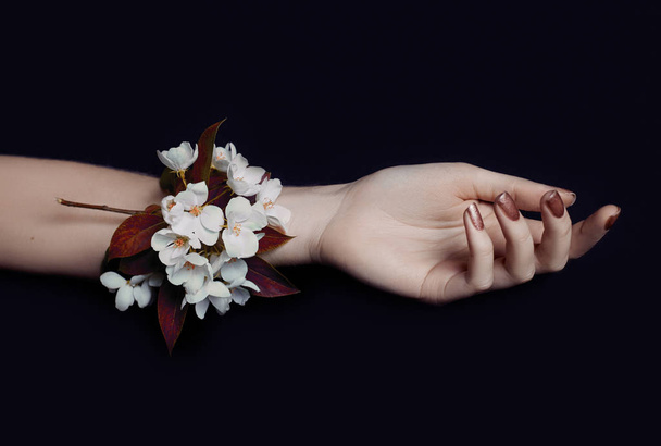 Fashion art hand woman in summer time and flowers on her hand with bright contrasting makeup. Creative beauty photo hand girls sitting at table on contrasting background with colored shadows. Skincare. - Zdjęcie, obraz