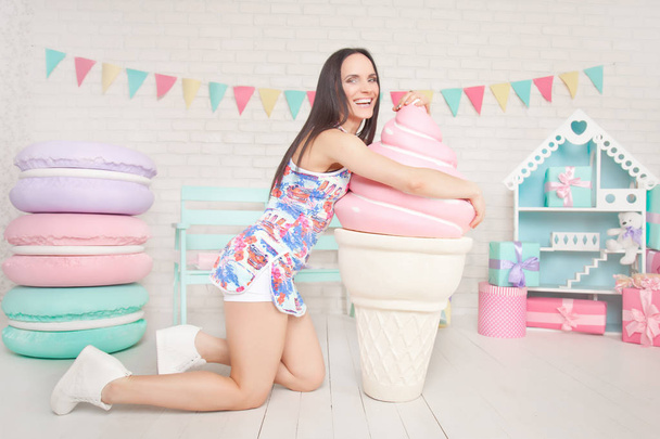 hermosa delgada chica fitness posando con un enorme dulces sobre un fondo blanco
 - Foto, Imagen