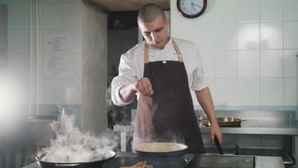 Ο μάγειρας προσθέτει μπαχαρικά και κρεμμύδι σε τρόφιμα - Πλάνα, βίντεο