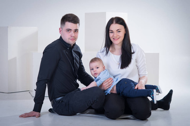 Joven familia feliz con bebé niño disparando en el estudio de fotos, s
 - Foto, imagen