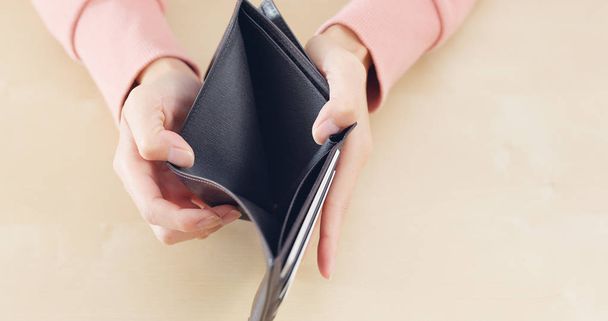 Mujer abriendo billetera vacía
  - Foto, Imagen
