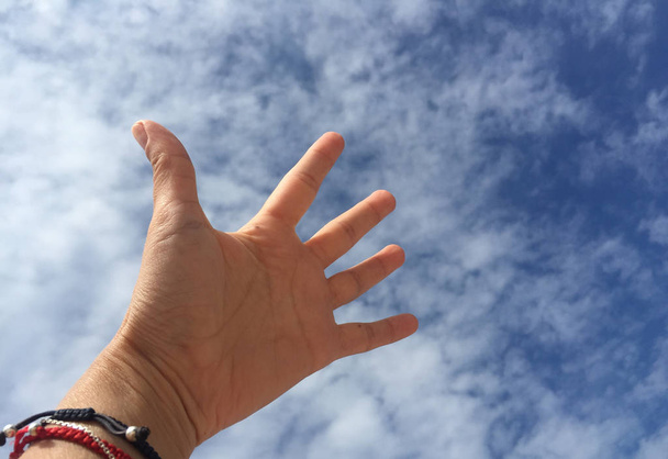 Une main / paume contre le ciel bleu
 - Photo, image