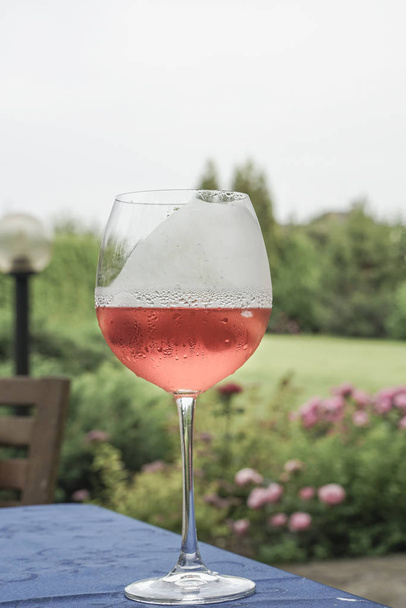Viinilasi pöydällä puutarhassa kesällä
 - Valokuva, kuva
