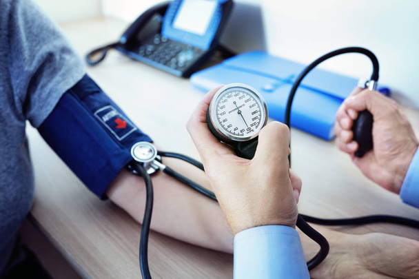 Doctor measuring blood pressure of patient - 写真・画像