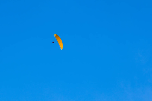 um parapente voando no céu azul em montanhas e vales landsca
 - Foto, Imagem