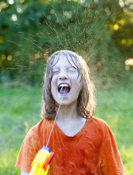 Natte Boy gek rond spuitende Water - Foto, afbeelding