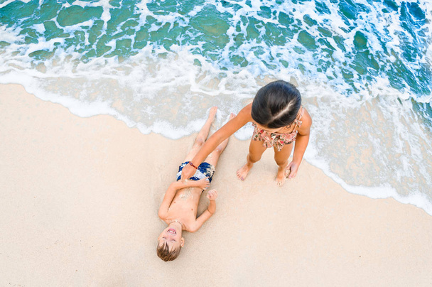 Deux enfants s'amusent sur la plage tropicale ensoleillée
 - Photo, image
