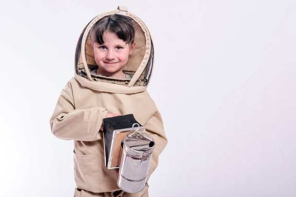Una niña pequeña lleva un traje de abeja de gran tamaño en el estudio de fondo blanco
. - Foto, imagen