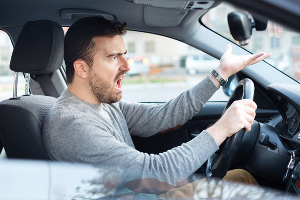 Vihainen ja töykeä kuljettaja muotokuva istuu autossaan
 - Valokuva, kuva