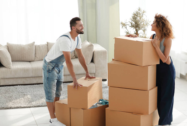 Happy and young couple looking at boxes - Foto, imagen