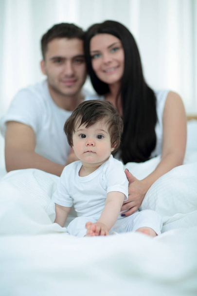 Happy couple and son sitting in bed - Photo, Image