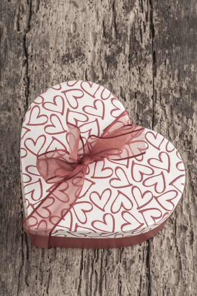 heart shaped gift on wooden table - Foto, afbeelding