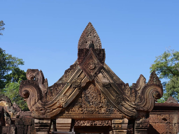 Сием Рип, Камбоджа - 23 декабря 2017 года: Бантей Срей - камбоджийский храм X века, посвящённый индуистскому богу Шиве. Он славится своей сложной отделкой, вырезанной из розового песчаника, который покрывает стены, как гобелен
.  - Фото, изображение