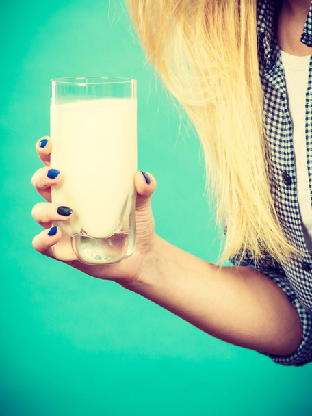 Woman hand holding glass of milk - Fotó, kép