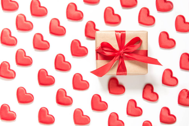 Pattern made of red hearts and one gift with bow on white background. Heart in isometric style. Valentine's card. - Fotoğraf, Görsel