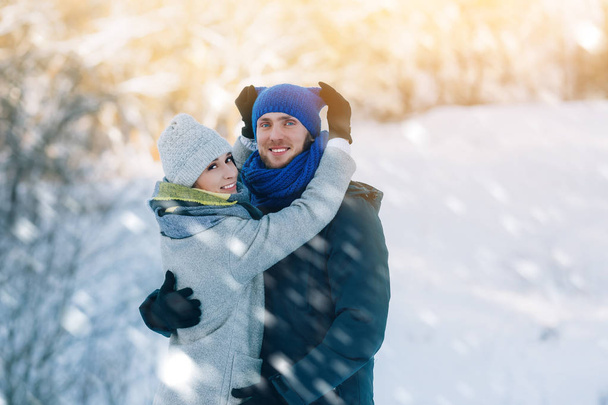 Happy νεαρό ζευγάρι στο χειμερινό πάρκο γελώντας και διασκεδάζοντας. Οικογένεια σε εξωτερικούς χώρους. - Φωτογραφία, εικόνα