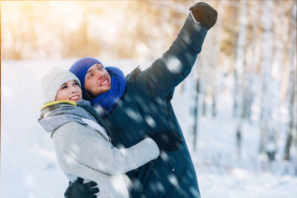 Happy Young Couple in Winter Park laughing and having fun. Family Outdoors. - Photo, Image
