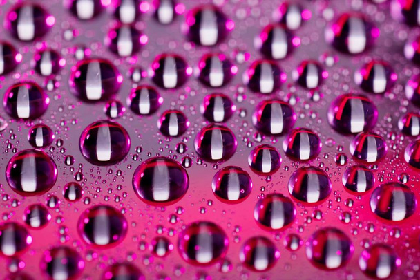 close up shot of drops on color background  - Фото, изображение