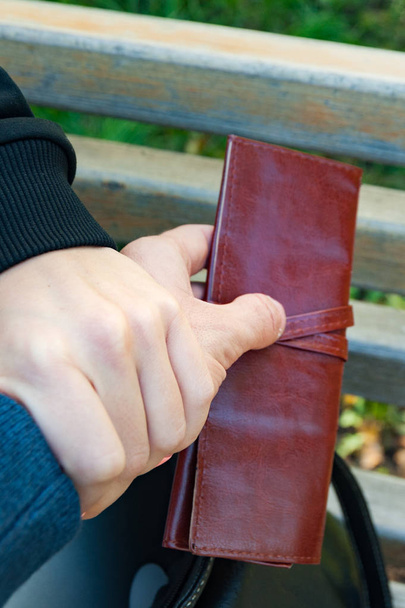 Вертикальный вид вора, крадущего бумажник из сумки, крупным планом
 - Фото, изображение