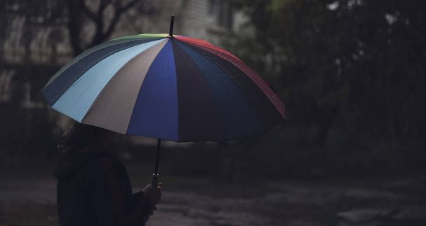 Panorama of man with colorful umbrella standing lonely and thinking in the rain weather, blur focus. Concept of loneliness and sadness - Zdjęcie, obraz