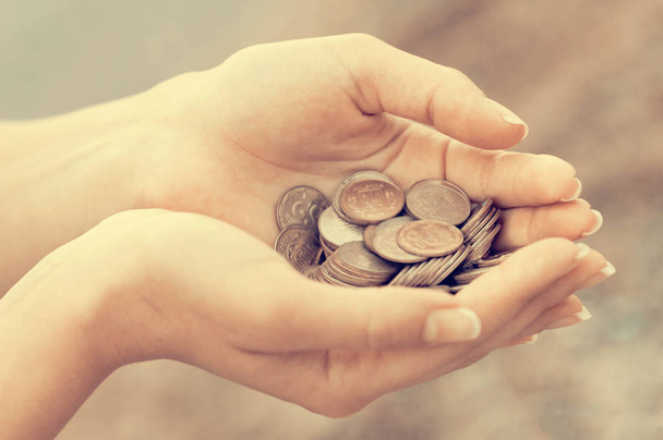 Горсть монет в ладони женских рук. Концепция сбережений и пассивного дохода
 - Фото, изображение