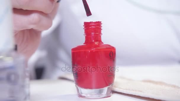 Manicure. Taking a dip from manicure bottle on foreground. Master applies varnish drawing on nails gel in spa . Closeup finger nail care by specialist in beauty salon. - Footage, Video