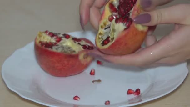 Cleaning of pomegranate fruits Cutting into pieces and cleaning the ripe red pomegranate fruit for the preparation of desserts - Filmmaterial, Video