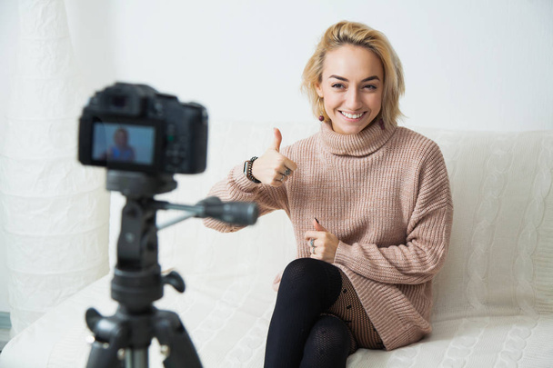 Blogging concept. Young female vlogger next to video camera at home. Beautiful woman recording vlog message at home for her internet channel - Photo, Image