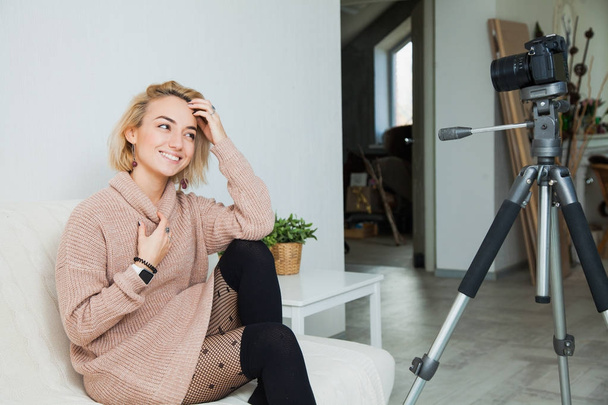 Blogging concept. Young female vlogger next to video camera at home. Beautiful woman recording vlog message at home for her internet channel - Foto, imagen
