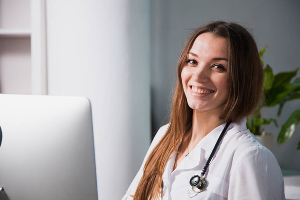 Портрет молодой профессиональной женщины-врача, улыбающейся в клинике. Крупный план лекарств в больнице
 - Фото, изображение