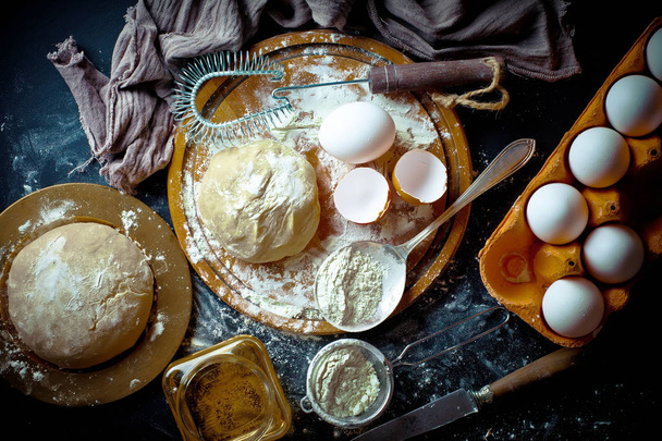 Dough with flour on an old background in a composition with kitchen accessories - Fotografie, Obrázek