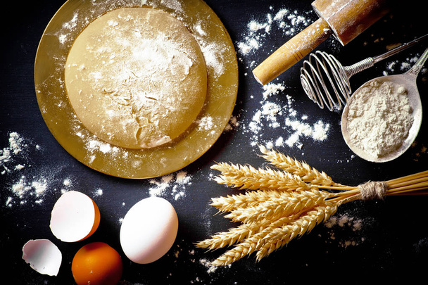 Dough with flour on an old background in a composition with kitchen accessories - Photo, Image