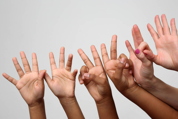 багато піднятих дитячих експресивних рук поспіль
 - Фото, зображення
