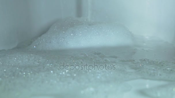Pour water into the bath With a strong flow of water from the tap, the bath is filled with water forming a lot of foam - Footage, Video
