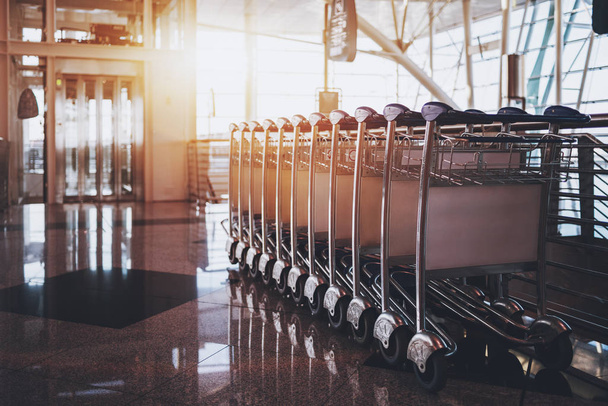 Terminal de aeroporto contemporâneo com carrinhos de bagagem
 - Foto, Imagem