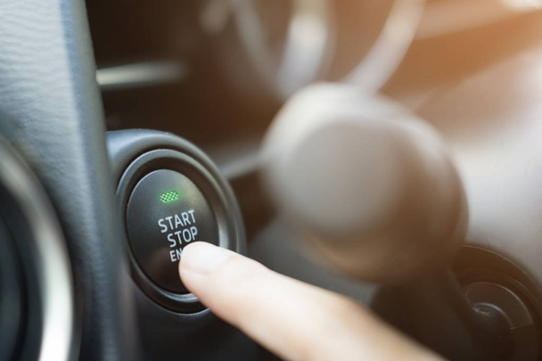 Zbliżenie na palec naciskający przycisk start/stop silnika w samochodzie. - Zdjęcie, obraz