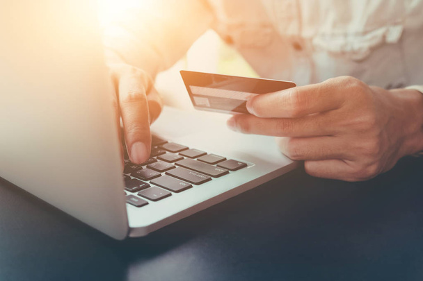 Pago en línea, manos del hombre sosteniendo la tarjeta de crédito y el uso de ordenador portátil para compras en línea
. - Foto, Imagen