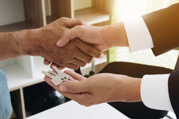Image of above view, Real estate broker agent and customer shaking hands and give keys after signing contract documents for realty purchase, Bank employees congratulate, Concept mortgage loan approval. - Photo, Image