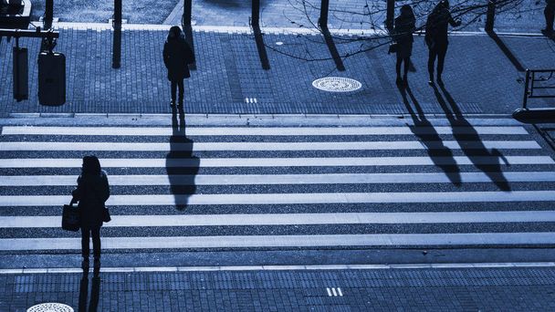 силуэт людей, идущих по пешеходному переходу на перекрестке
 - Фото, изображение
