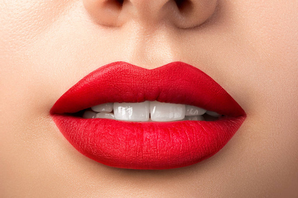 Close up view of beautiful woman lips with red matt lipstick - Photo, image
