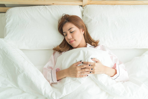 asian woman sleeping on bed - Фото, изображение