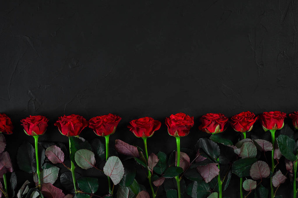 Bouquet of red roses on a black background. Top view - 写真・画像
