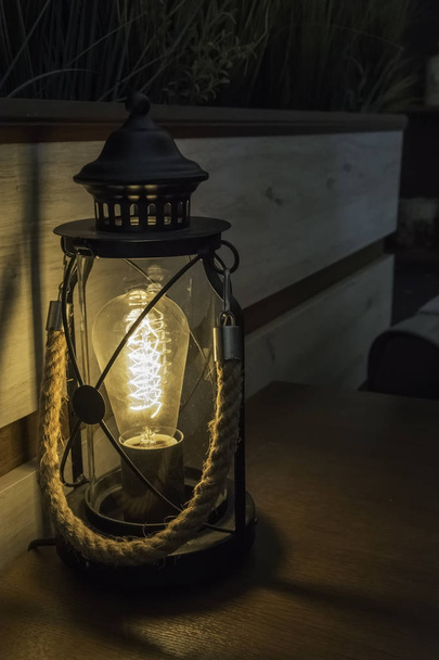 Lanterna elettrica in un tavolo da bar con impugnatura in corda. ombra e lig
 - Foto, immagini