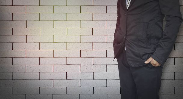 επιχειρηματίας που στέκεται πάνω σε τούβλα τοίχος φόντο με αντίγραφο χώρου - Φωτογραφία, εικόνα