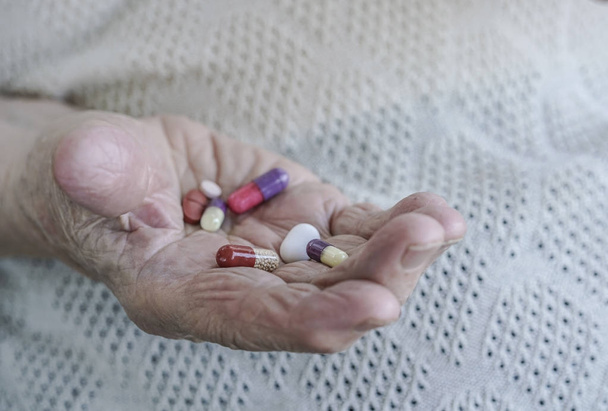 algunas pastillas en la palma de una mujer mayor
 - Foto, Imagen