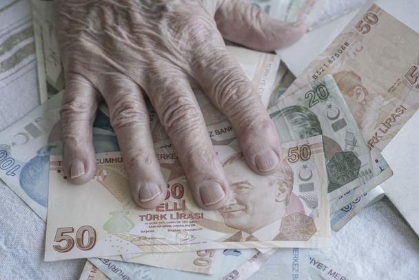Türk Lirası banknotların üzerinde üst düzey bir kişinin kırışmış el - Fotoğraf, Görsel