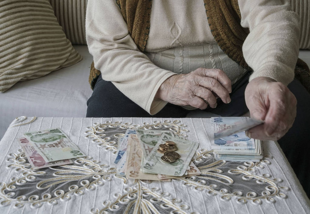 Closeup ζαρωμένα χέρια ένα ανώτερων γυναίκα καταμέτρησης χαρτονομισμάτων Τουρκική Λίρα - Φωτογραφία, εικόνα